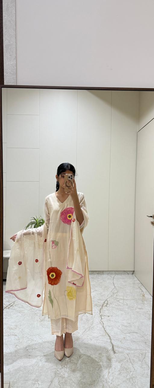 Woman taking a mirror selfie wearing a floral dress in a bathroom.